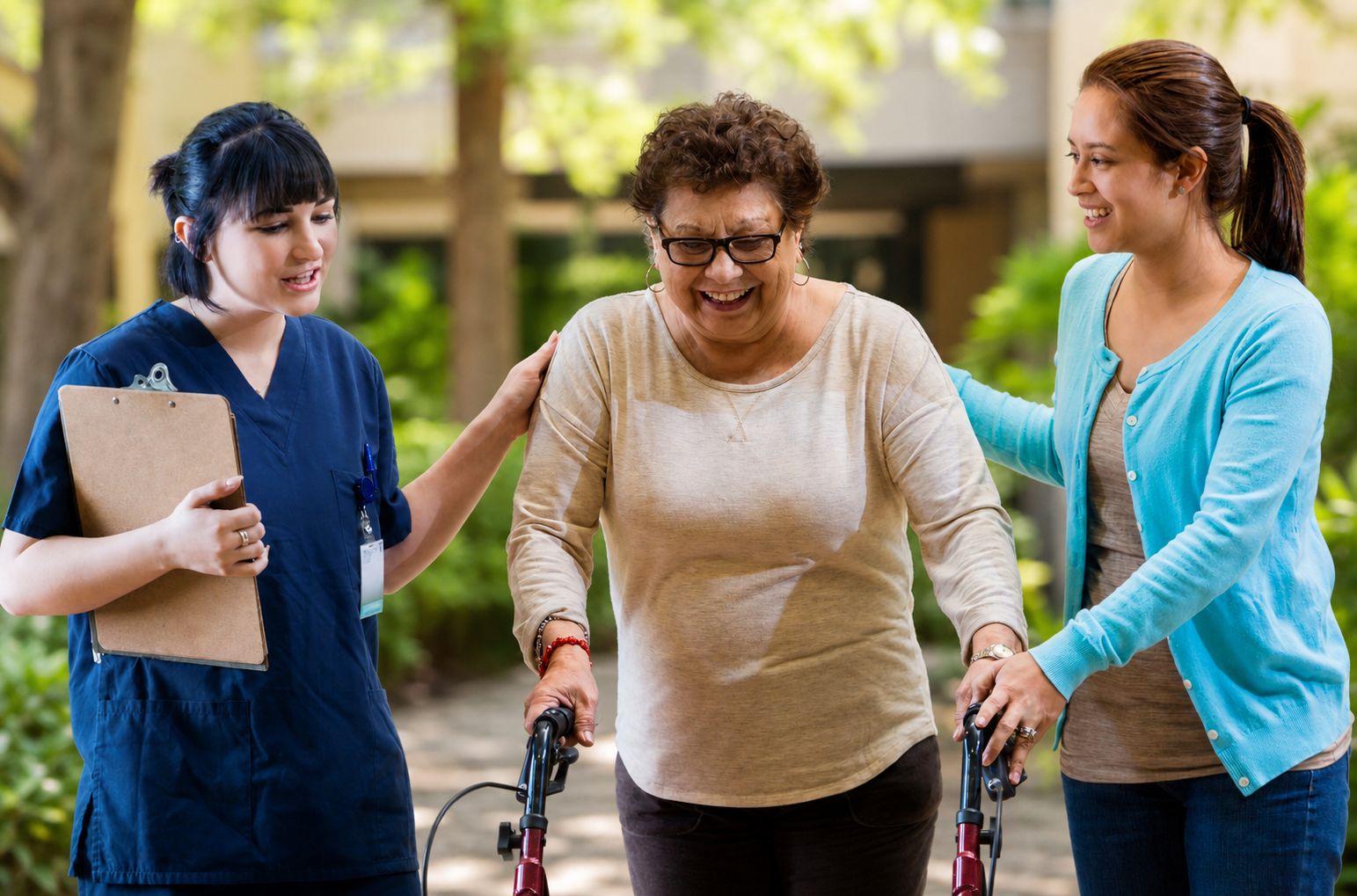 Senior woman walking outdoors with a walker, supported by a caregiver and a family member, at Covina Court Senior Living in Whittier