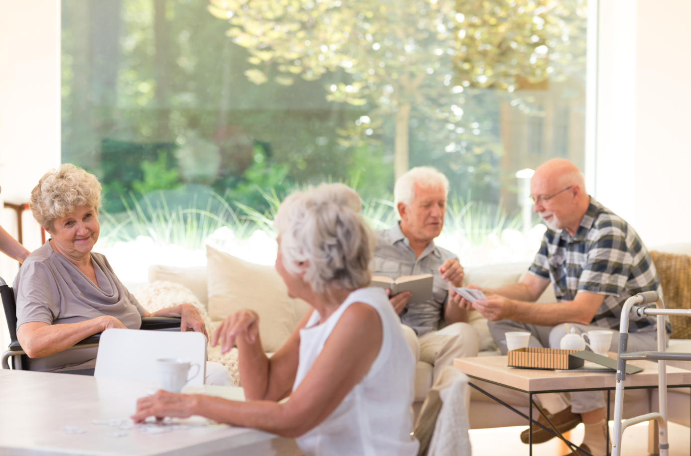 Seniors socializing in a bright, comfortable common area at Covina Court Senior Living
